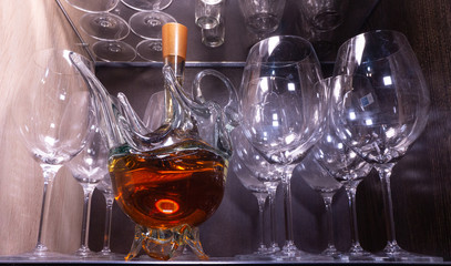 a bottle of cognac in the shape of a Swan on the shelf with glasses