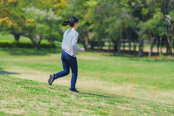 Japanese young woman running at park in spring