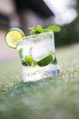 mojito cocktail lime juice with soda and water served in a glass decorated with sliced lime and mint leaves