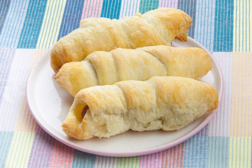 Crispy pies sausages on a plate on  wooden background