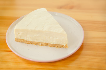classic cheesecake on white plate on  wooden table