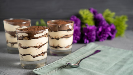 Perfect morning delicious tiramisu dessert. Best sweet present for your lover. Tiramisu and flowers. Yummy breakfast.