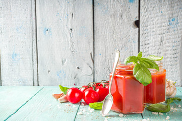 Healthy lunch fast food concept. Cold gazpacho soup. Tomato cream soup in a jar, on a summer wooden background.