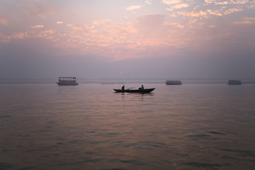 Amanecer en el río Ganges en Varanasi, India. Barcos con pescadores y cielo rosa y lila.
