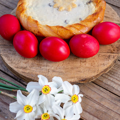 traditional romanian easter dish cozonac and pasca or sweetbread and cheese pie like on wooden table and colored easter eggs and flowers