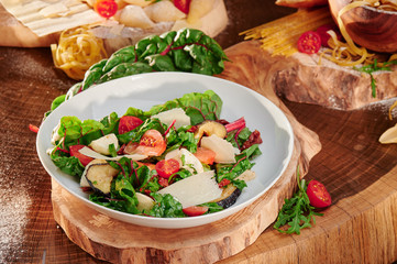 Vegetarian Salad with tomatoes, mozzarella, parmesan and fried eggplant on a wooden background. Traditional italian salad. Close-up.