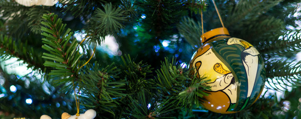 cartolina di natale con albero e luci natalizie e ciondolo