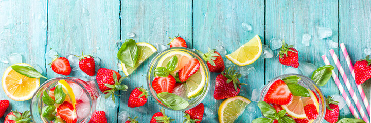 Strawberries and basil lemonade. Summer cold iced cocktail recipe, with fresh strawberry, lemon and basil leaves, wooden background copy space