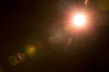 Abstract Natural Sun flare on the black background. - obrazy, fototapety, plakaty