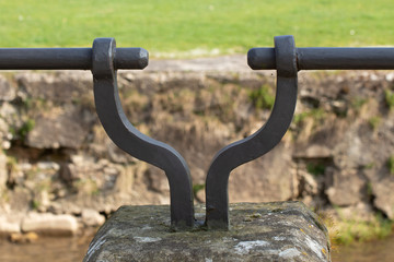 Close up of a old metal railing attached to a sandstone pillar