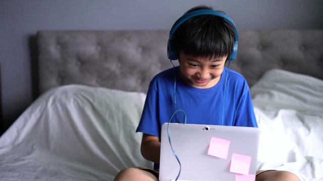 A boy wearing headphone for play game at home.  