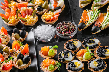delicious snack tartlets on dark stone background