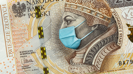 Coronavirus in Poland. Quarantine and global recession. 200 Polish zloty banknote with face mask against infection. Global economy hit by covid19.National Bank of Poland prints money to save bugdet