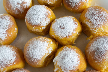Round buns sprinkled on a white plate top view.