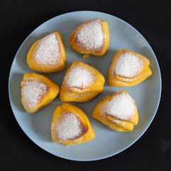 Triangular buns on a blue round plate on a black background.