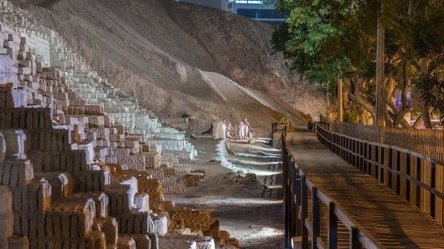 Pyramid of Huaca Pucllana night timelapse, pre Inca culture ceremonial building ruins in Lima, Peru. Wooden footbridge on a side going to sculptures