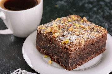 Brownie cake and freshly brewed black coffee for breakfast or dessert on a dark background