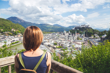 Fototapeta na wymiar Holiday in Salzburg: Young girl is enjoying the view. Historic district, Festung Hohensalzburg