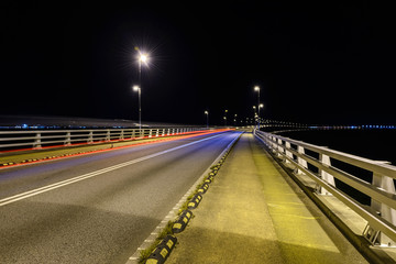 light from car lights in the night on a bridge