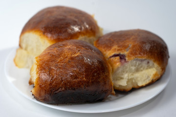 Sweet buns on a dish. Baked hot homemade buns. Isolated on a white background