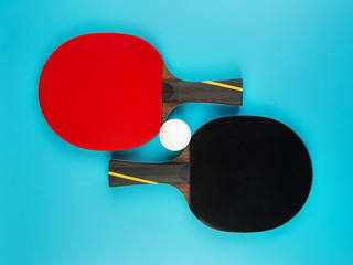 tennis rackets and a ping-pong ball on a blue background
