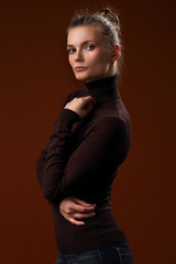 Beautiful girl in a maroon turtleneck on a brown background