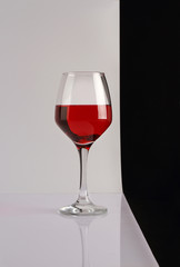 A glass of red wine on a glossy white table