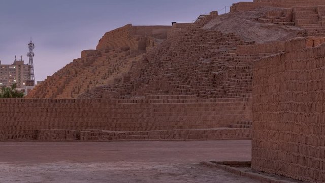 Pyramid of Huaca Pucllana day to night transition timelapse, pre Inca culture ceremonial building ruins in Lima, Peru. Clouds on a sky. Illumination is turning on