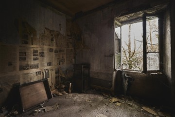 Old room with the walls covered in newspapers under the lights in an abandoned building