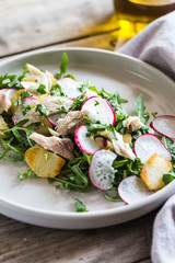 Fresh salad with radishes, potatoes, arugula and mackerel or tuna. diet concept