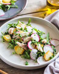 Fresh salad with radishes, potatoes, arugula and mackerel or tuna. diet concept