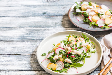 Fresh salad with radishes, potatoes, arugula and mackerel or tuna. diet concept