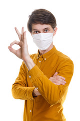 Stop the infection A healthy man shows the OK gesture. In the photo, the man is wearing a protective mask against infectious diseases and flu.