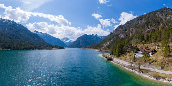 idyllic holiday house next to road at lake plansee in spring with austrian mountains