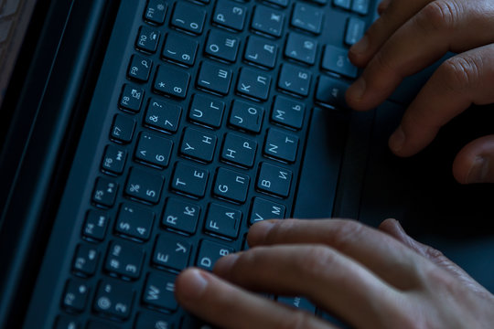 Male hands on a laptop keyboard close-up. Selective focus.
