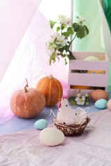 Fototapeta na wymiar Happy Easter, eggs, toy chicken, pumpkins, apple tree flowers in a basket on a windowsill, spring, pink color, interior decor for the holiday