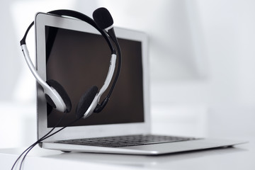 Call center and communication support, customer service help desk. VOIP headset on laptop computer