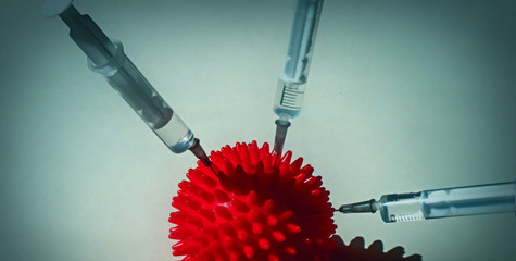 Syringe and red Coronavirus symbol. Injection of a cure for the virus COVID-19. Medical concept of...