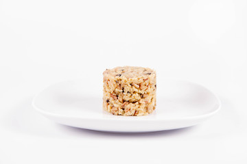 Risotto with button mushroom and bacon on a plate on a white background