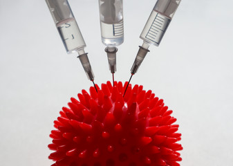 Syringe and red Coronavirus symbol. Injection of a cure for the virus COVID-19. Medical concept of...