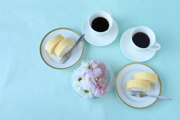 Obraz na płótnie Canvas ロールケーキとコーヒーとピンクの花