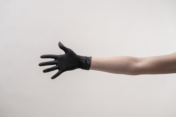 Fototapeta premium Hands in black silicone gloves on a light background.