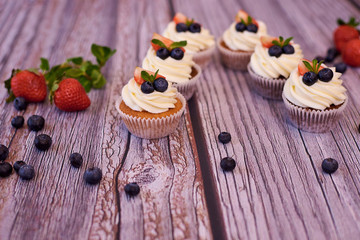 Cupcakes with strawberries and blueberries. Selective focus.