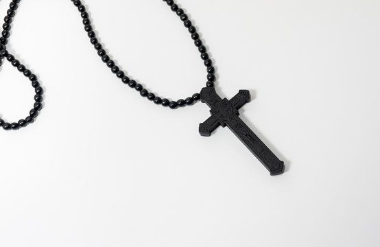 Wood rosary in white background. Brown wooden beads.