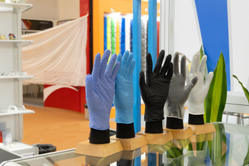 Colorful medical rubber gloves worn on artificial hands. Exhibition of medical equipment.