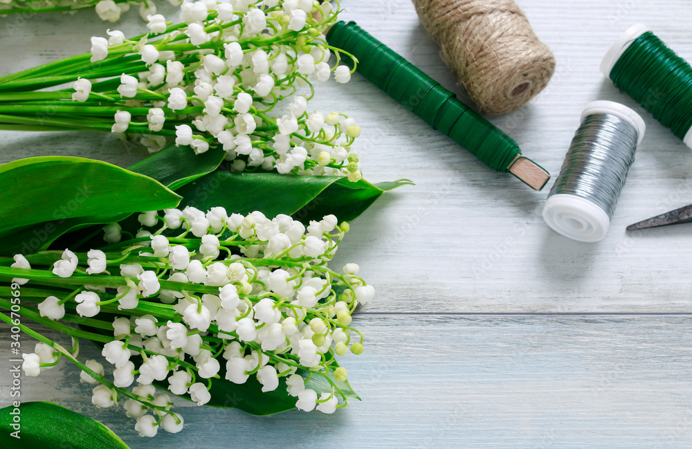 Sticker Lily of the valley and some florist's accesories on wood