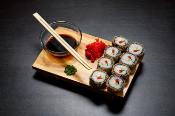 Tasty and delicious hot and cold sushi rolls on the table. Different sushi - rolls with sauce on the board of Japanese cuisine.