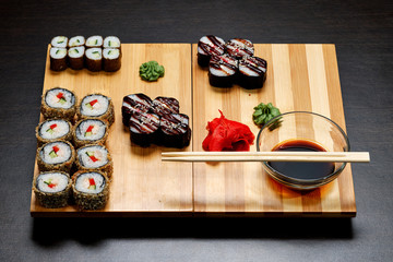 Tasty and delicious hot and cold sushi rolls on the table. Different sushi - rolls with sauce on the board of Japanese cuisine.