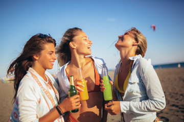 Group of three beautiful attractive young women having fun on the beach.