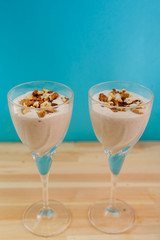 Two glasses with a banana smoothie of chocolate and ice cream on a blue background.